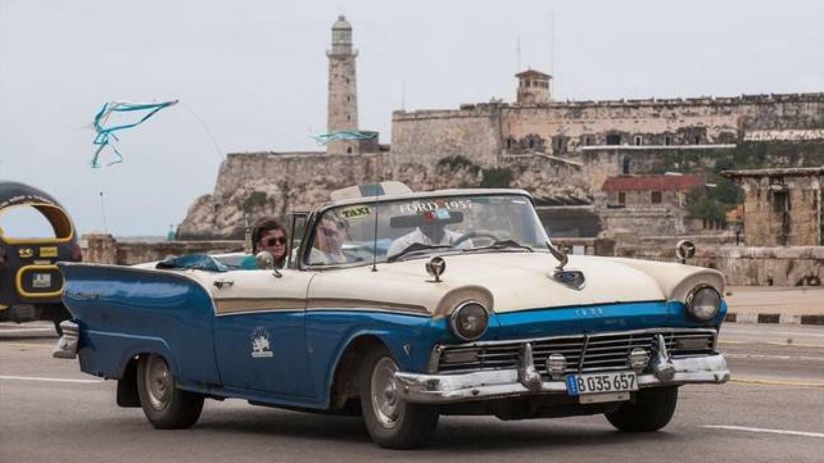 Unos turistas se desplazan en taxi por La Habana, el 8 de enero del 2014.-Foto: AFP / YAMIL LAGE