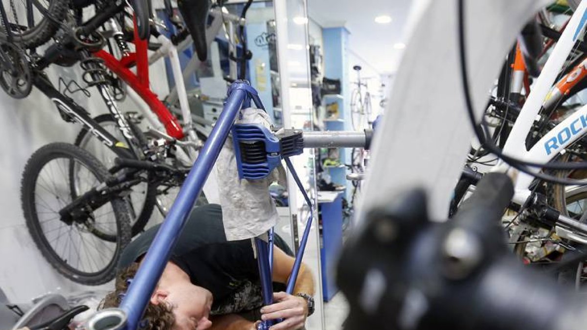 Un autónomo trabaja en su taller de bicicletas.-RAÚL G. OCHOA