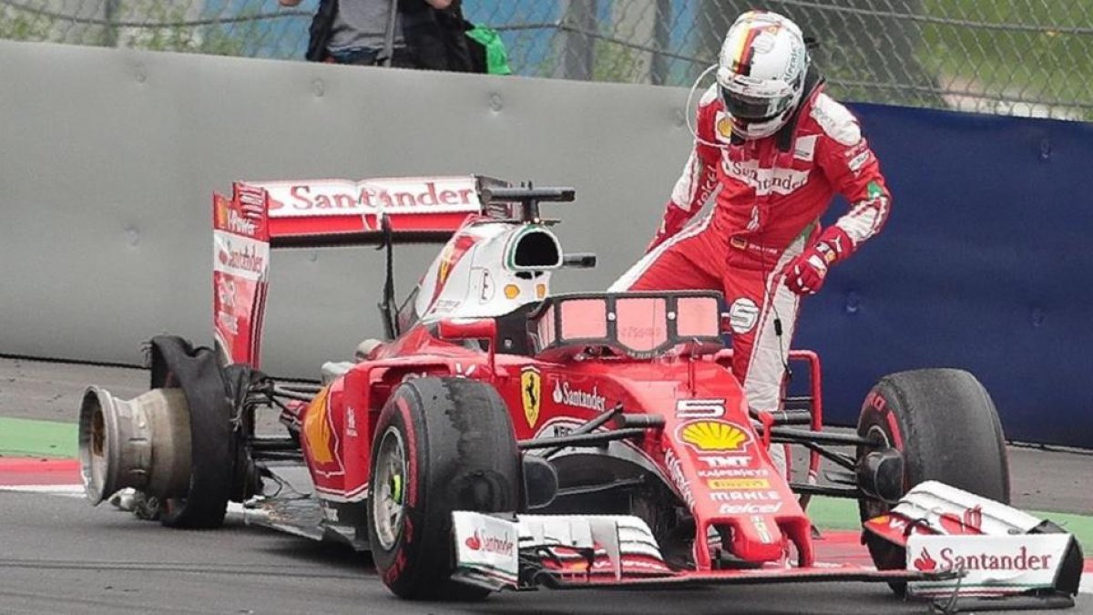 Sebastian Vettel se baja de su Ferrari tras estallar una de sus ruedas.-GEORG HOCHMUTH