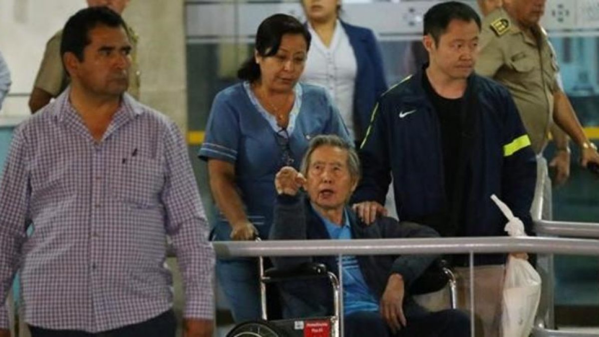 El expresidente peruano Alberto Fujimori saluda a sus simpatizantes junto a su hijo, el congresista Kenji Fujimori, al salir de la Clínica Centenario en Lima.-LUKA GONZALES