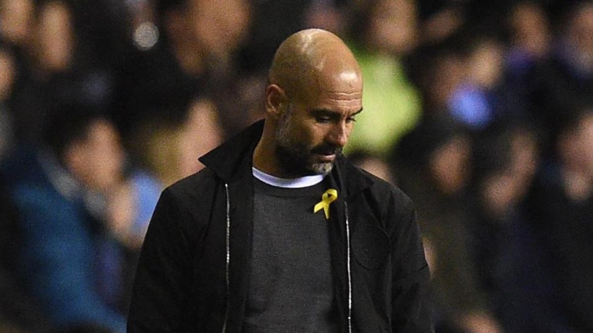 Pep Guardiola, con el lazo amarillo durante un partido del Manchester City.-/ AFP / OLI SCARFF