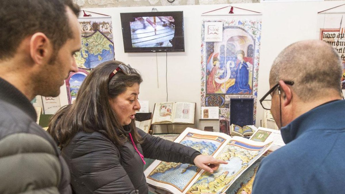 Tres personas observan uno de los ejemplares expuestos en el salón.-SANTI OTERO