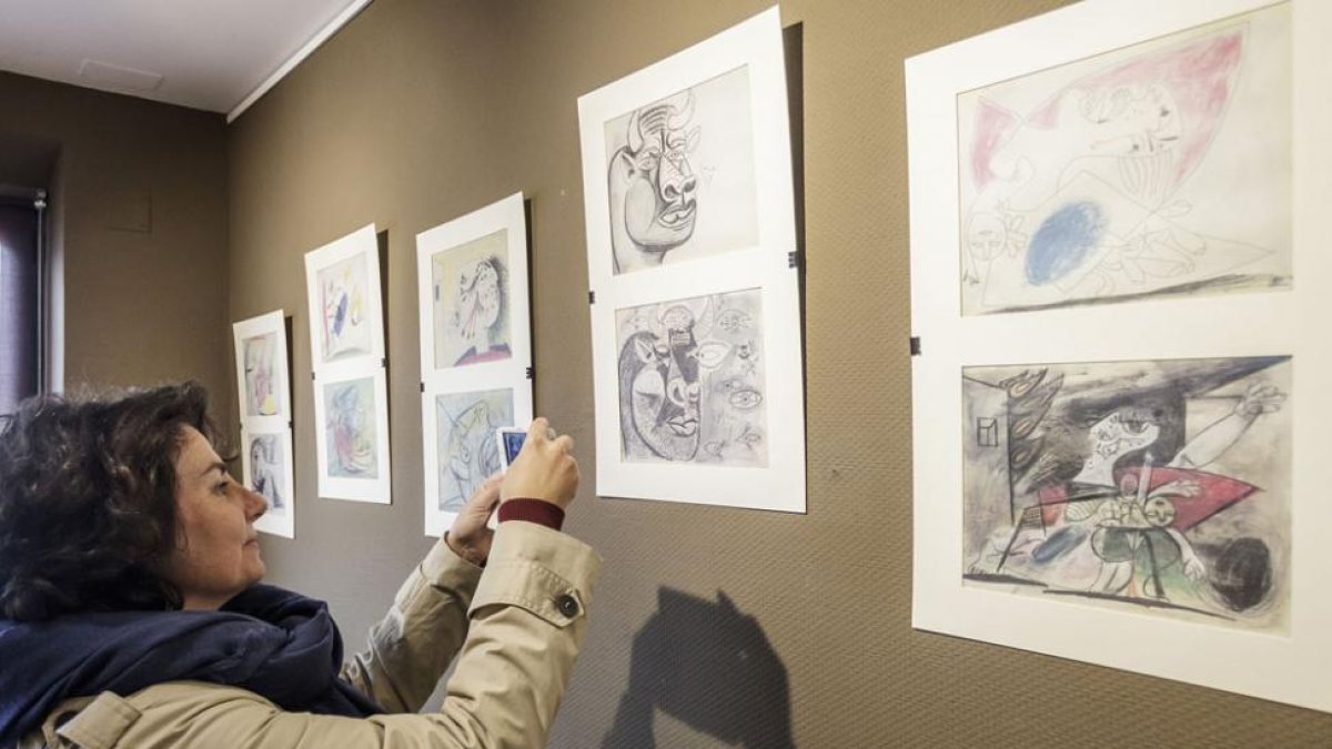 Una visitante fotografía algunos de los bocetos de la muestra.-Santi Otero