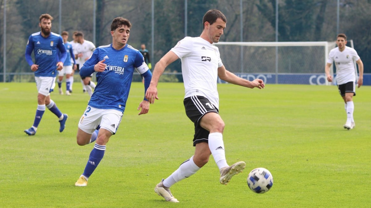 Claudio Medina controla el balón ante el jugador carbayón Jorge Mier. BURGOS CF / ALBA DELGADO