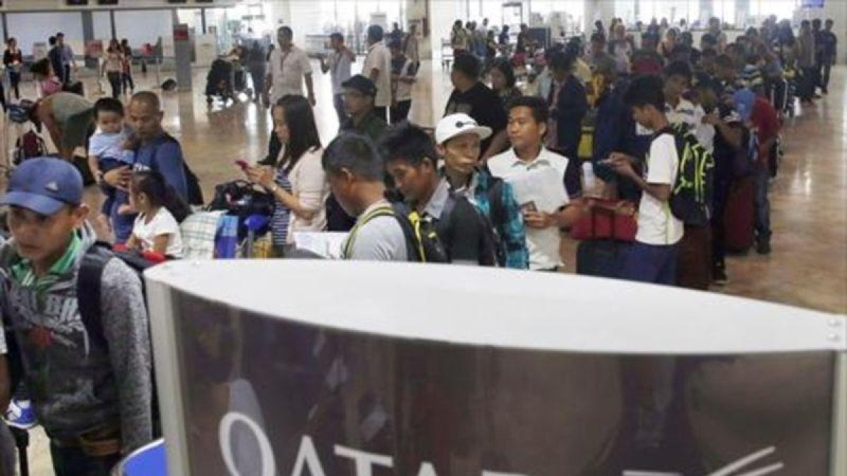Trabajadores filipinos, a la espera de poder viajar a Qatar.-AP / BULLIT MARQUEZ