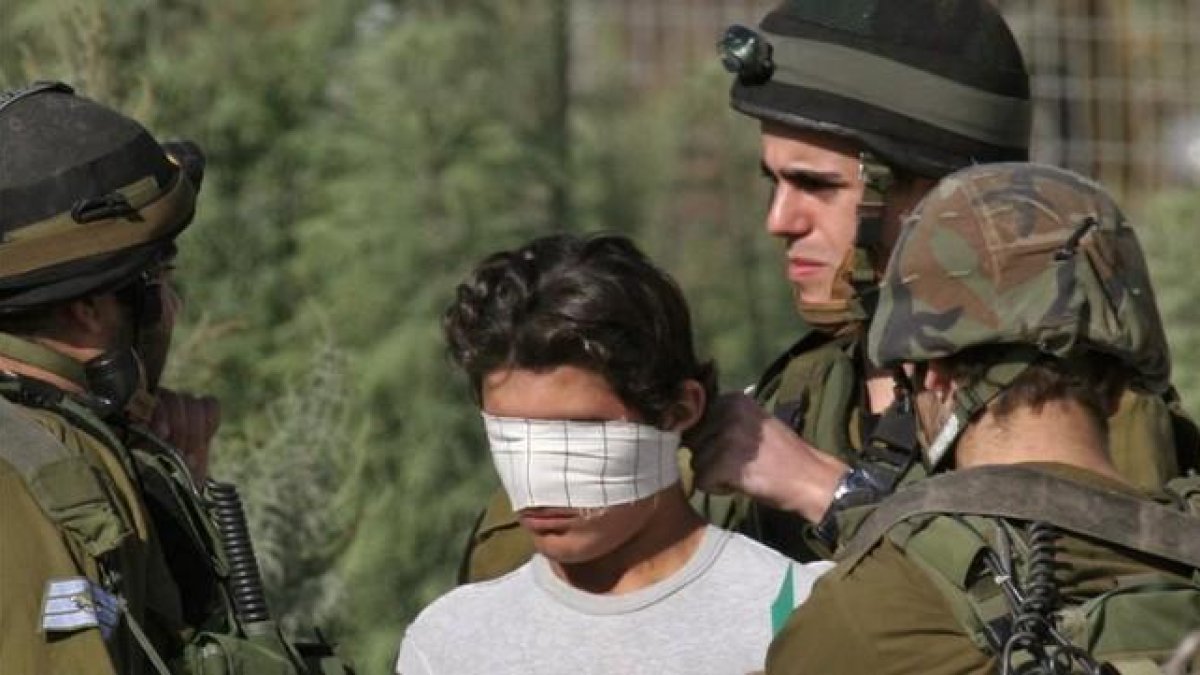 Un soldado israelí venda los ojos de un detenido palestino cerca de Nablus, en Cisjordania.-AP / NASSER ISHTAYEH