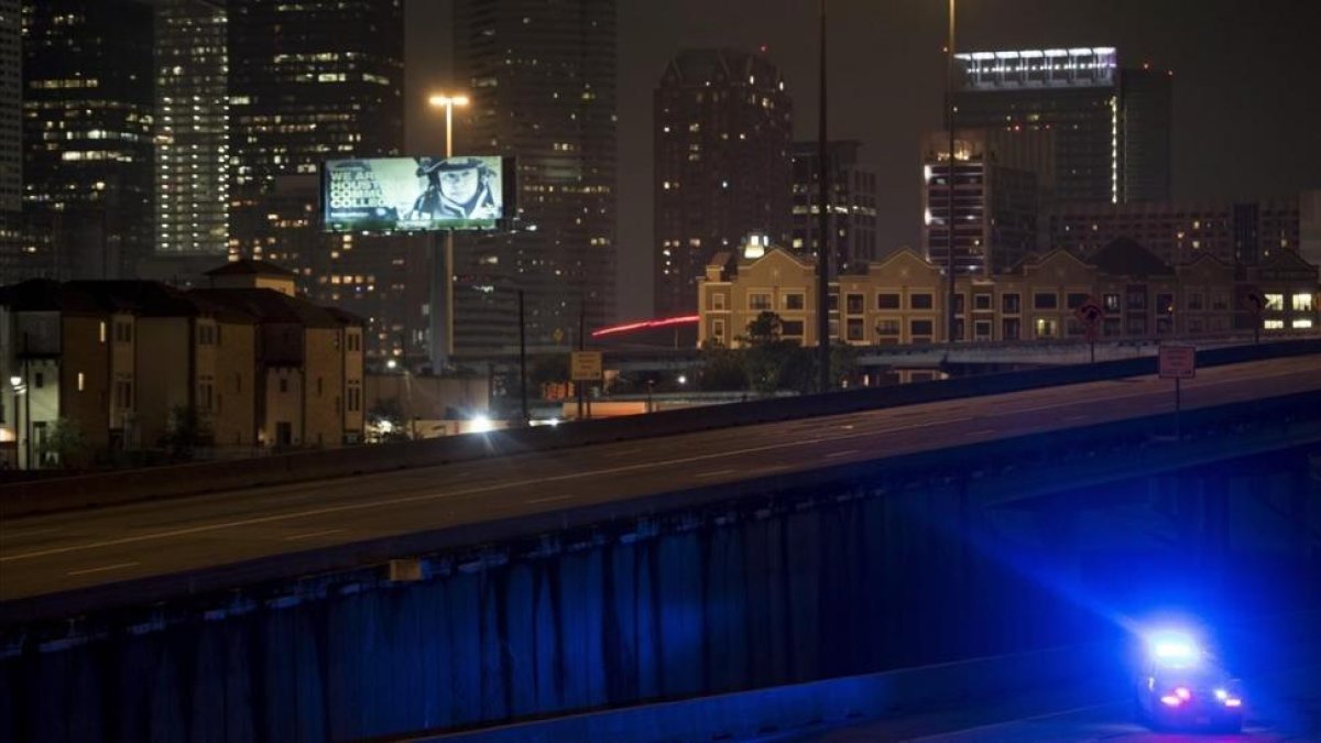 Un coche de policía patrulla las calles de Houston después del anuncio del toque de queda anunciado por el alcalde de la ciudad, Sylvester Turner-BRENDAN SMIALOWSKI