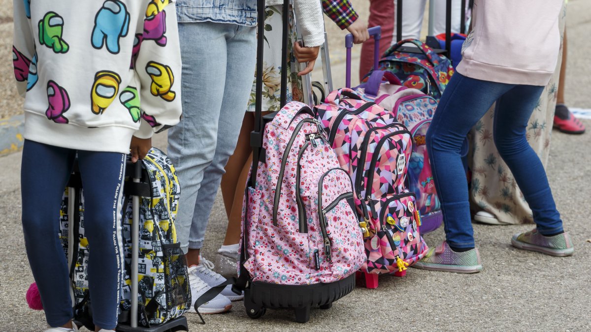 Alumnos y sus mochilas en la vuelta al cole. 