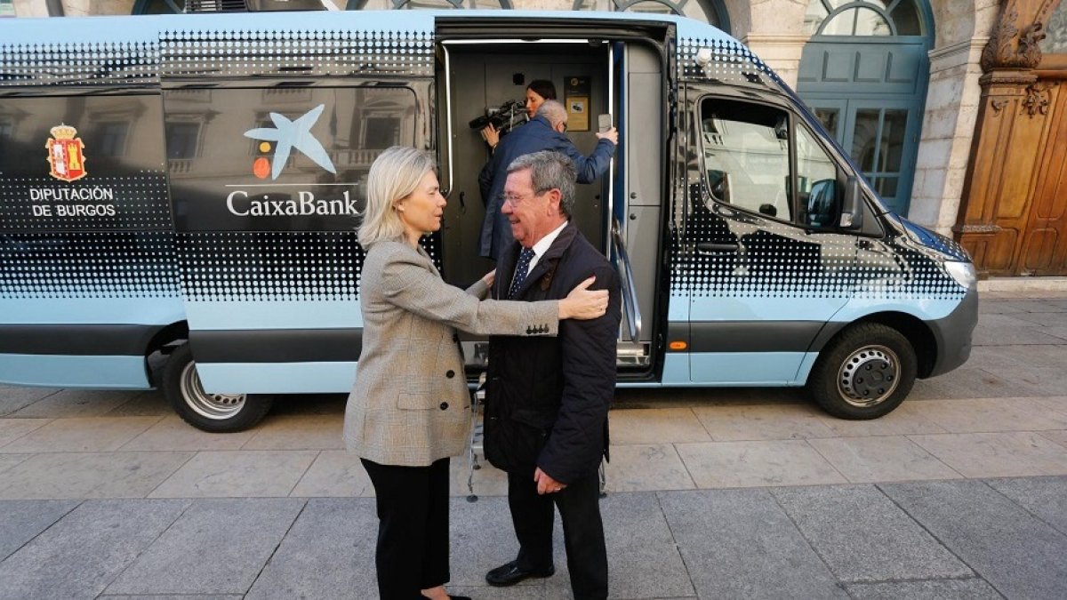Belén Martín (CaixaBank) y César Rico ante la oficina móvil que prestará servicio financiero en 46 pueblos de Burgos. SANTI OTERO