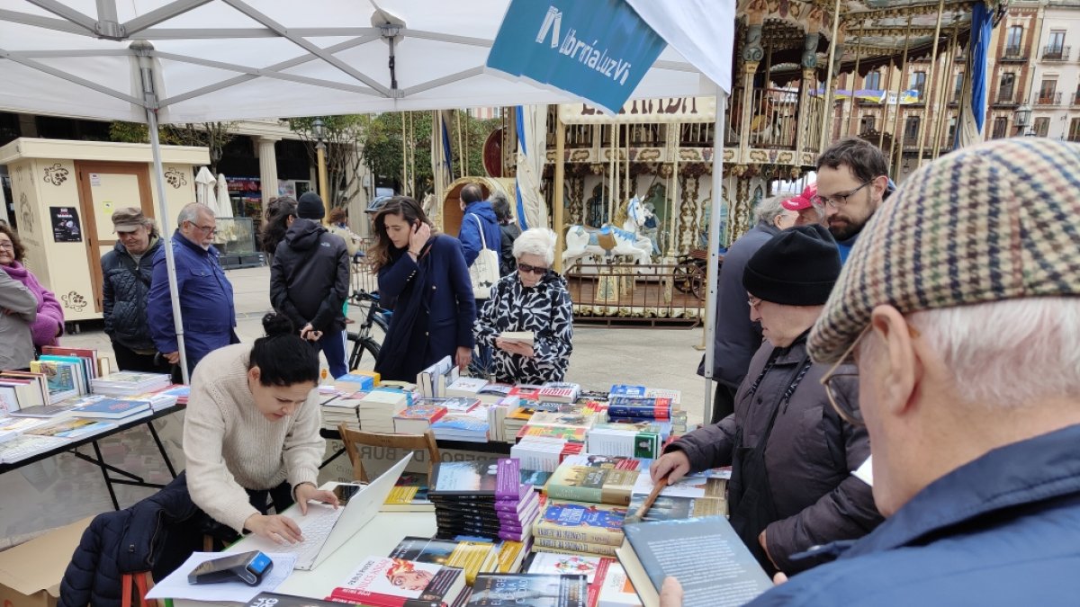 Varias personas ojean libros en uno de los puestos. SANTI  OTERO