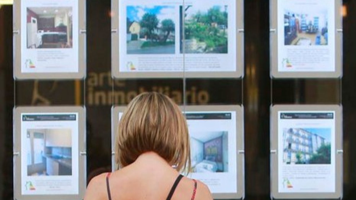 Una mujer mra anuncios en una inmobiliaria de la capital. ECB