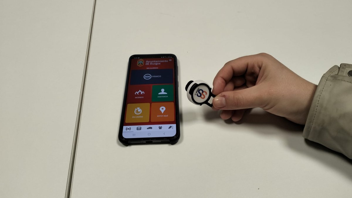 Este es el botón del pánico, un dispositivo bluetooth que la mujer puede activar y la aplicación del móvil que es la que conecta directamente con el sistema de alertas de la Policía Local.