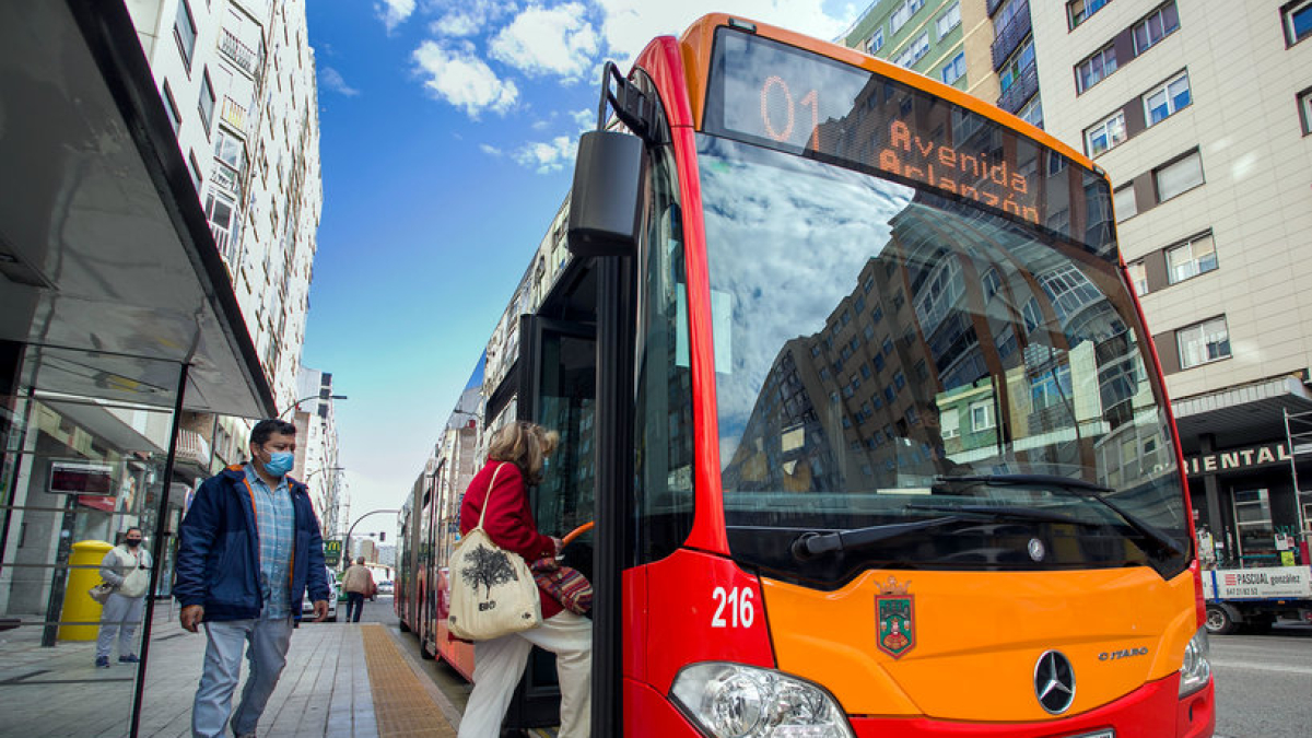 Varias personas se suben en un autobús.