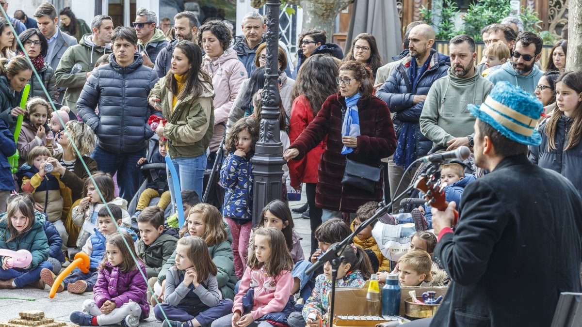 Varias personas disfrutan de un espectáculo de calle.
