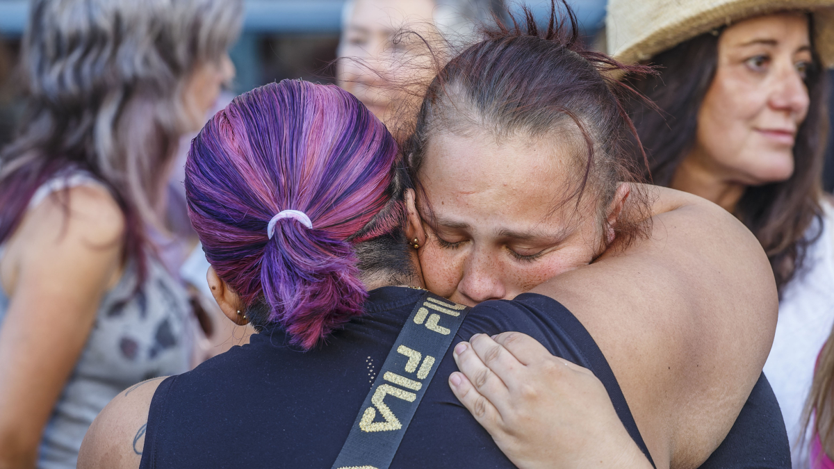 La hermana de la joven se abraza con una mujer en la concentración.