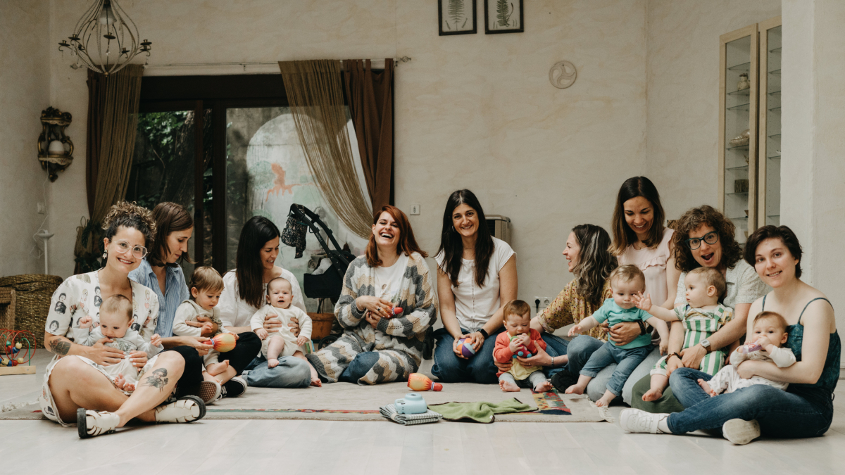Las madres participantes con sus hijos y Raquel en el centro durante una de las sesiones del grupo.