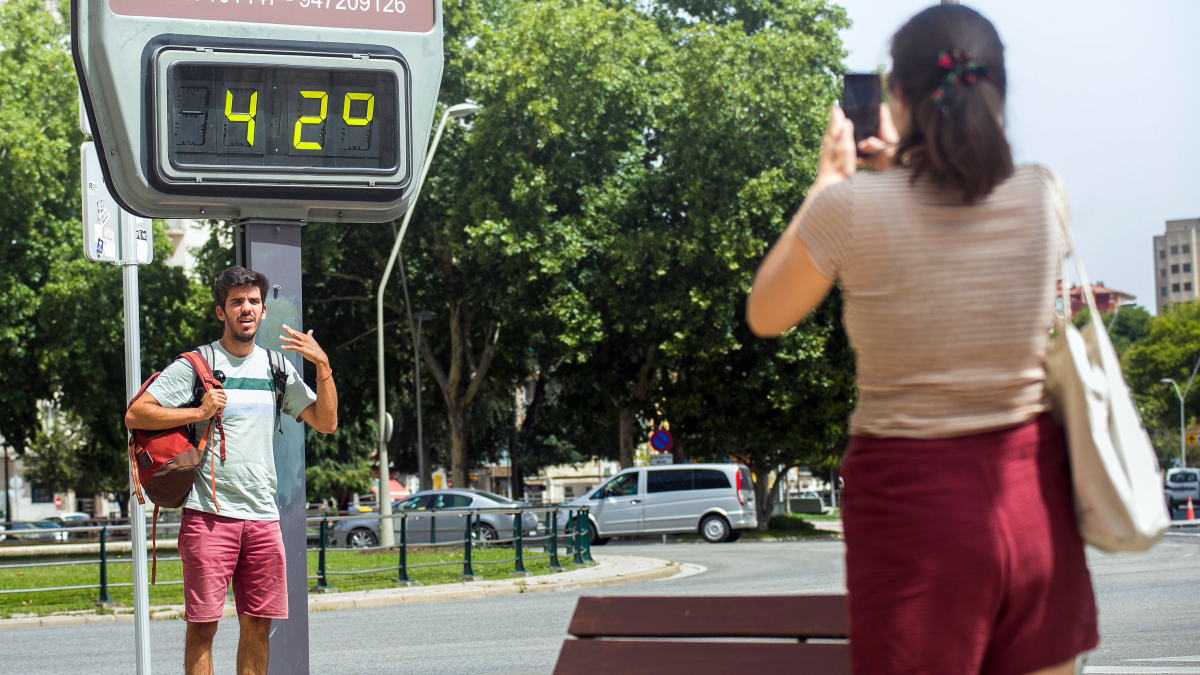 Una pareja se hace una foto junto a un termómetro de la capital.