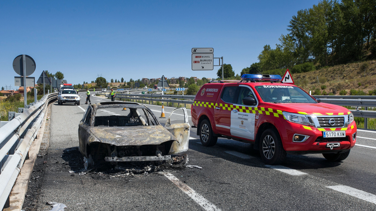 Imagen de un vehículo de Bomberos junto un coche calcinado en la A-62.