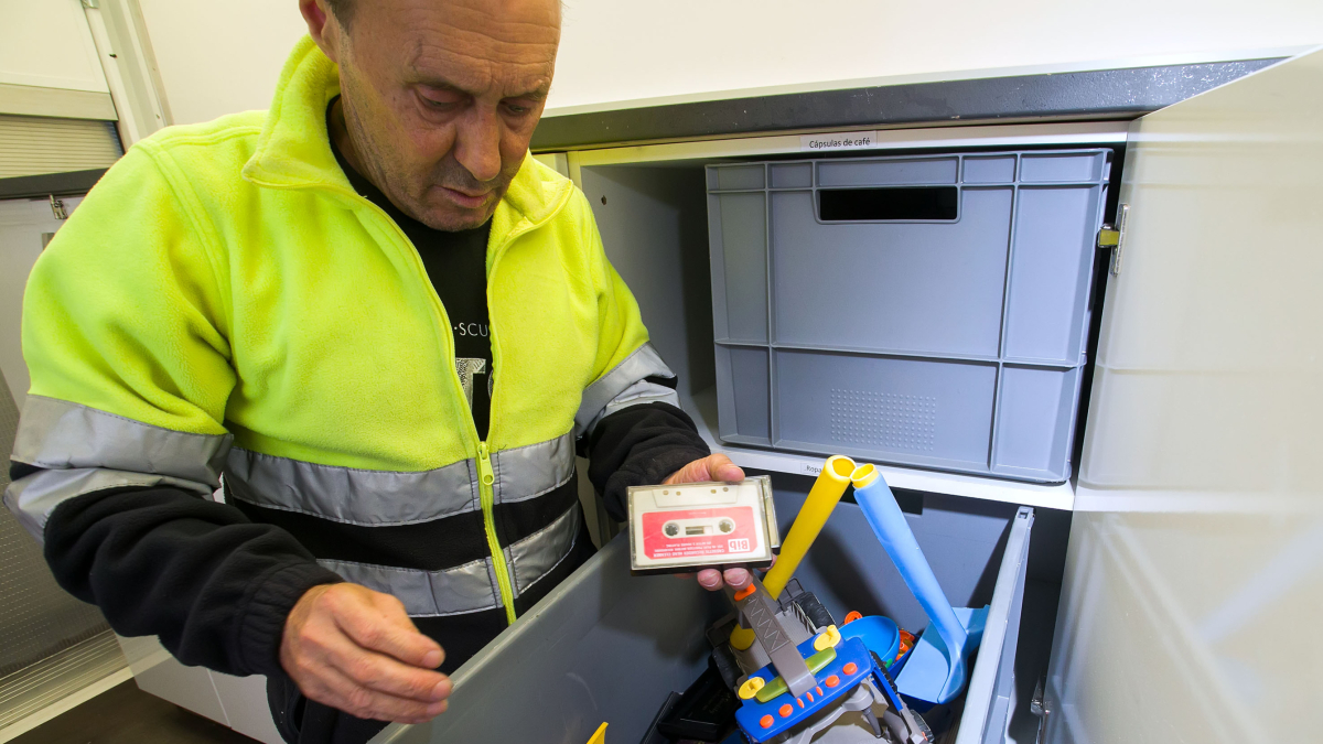 El operario del punto limpio móvil muestra una cinta de casete, recogida en una de las paradas del camión.