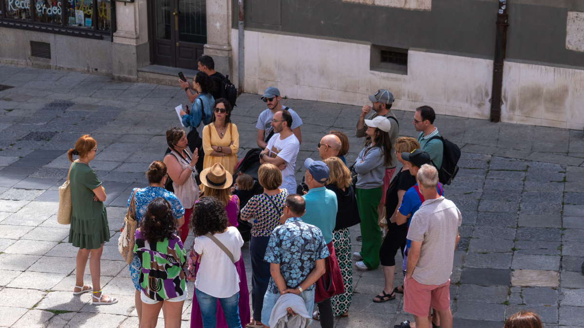 Un grupo de turistas escucha la explicación de una guía de la ciudad.