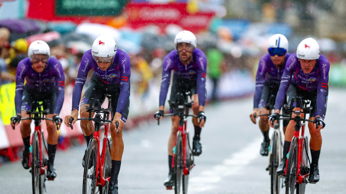 Los corredores del Burgos BH cruzan la meta bajo la lluvia en la contrarreloj por equipos de la Vuelta a España 2023.