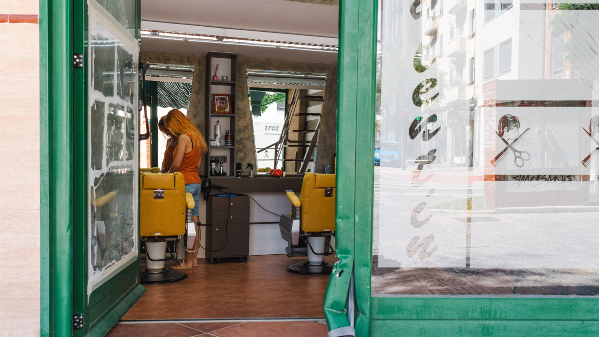Regina González, en el interior de la peluquería que regenta, en cuya entrada permanecen aún las pruebas del suceso.