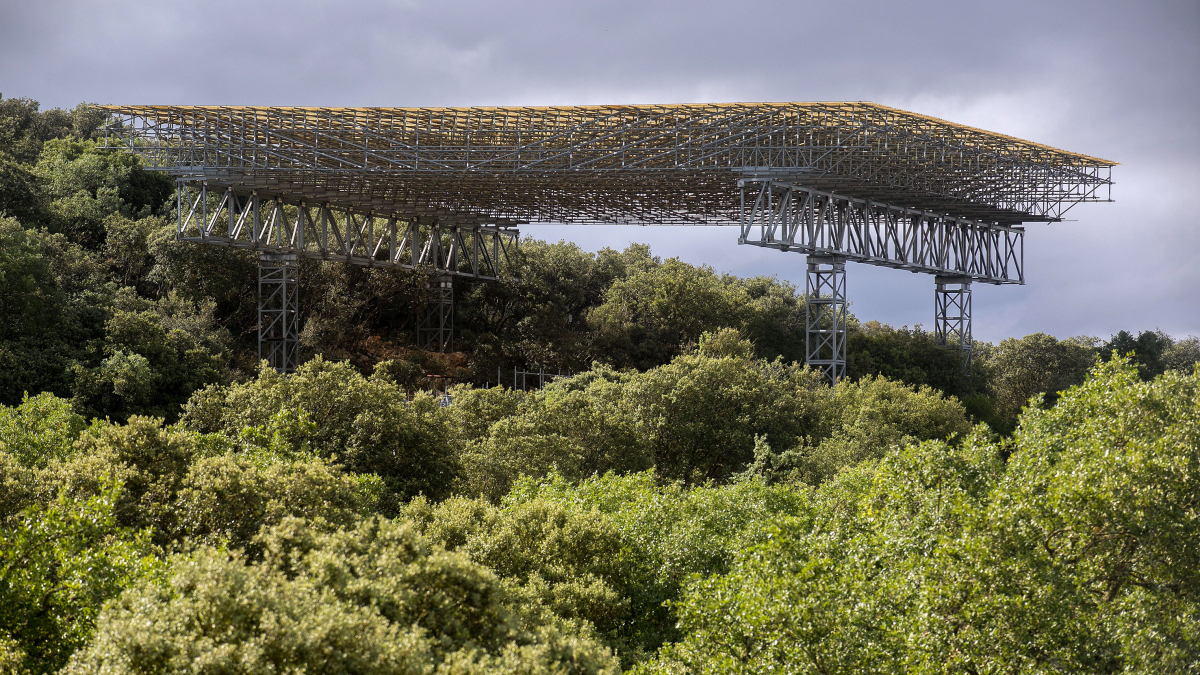 Entre la masa forestar de las estribaciones de la sierra de Atapuerca se alza la cubierta de la zona de excavación arqueológica.