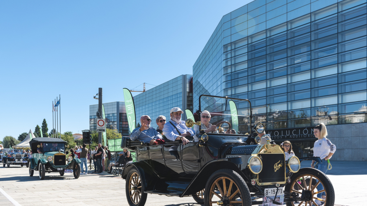 Varias personas disfrutan de un paseo en coche clásico.