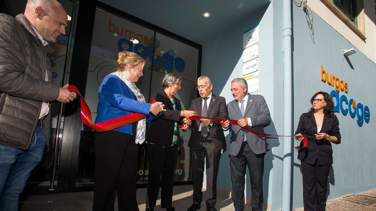La presidenta de Burgos Acoge, Asunción Cifuentes, corta la cinta inaugural de sus nuevas instalaciones en presencia de representantes de las distintas administraciones.