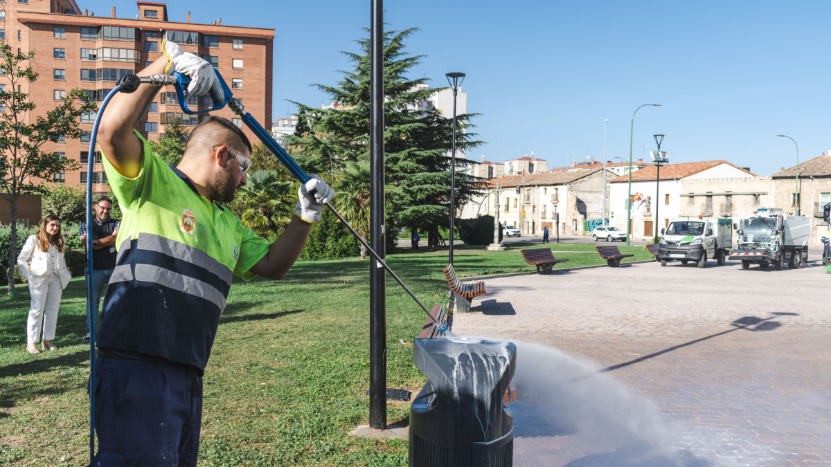 Un operario de Urbaser muestra como se limpian las pintadas vandálicas sobre una papelera, en el entorno de la Real y Antigua de Gamonal.