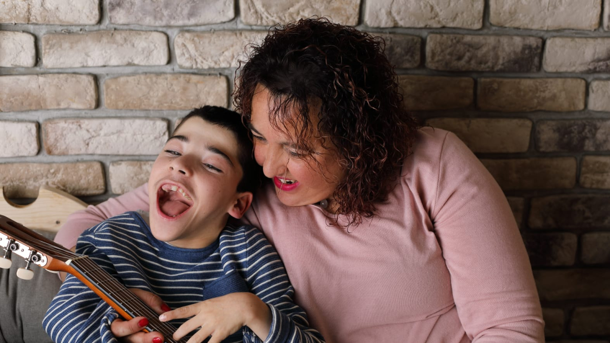 Izhan y su madre Elena se divierten con una guitarra. ECB