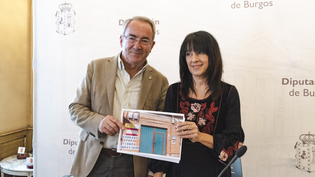 Ángel Carretón e Inmaculada muestra una foto con el cartel de cerrado en el cuartel de Villadiego.