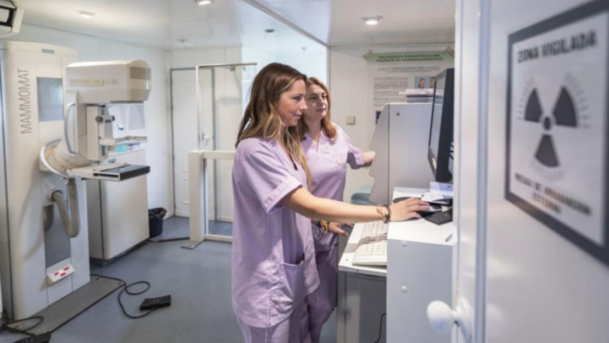 Dos profesionales manejan un equipo de mamografía para la detección del cáncer de mama.