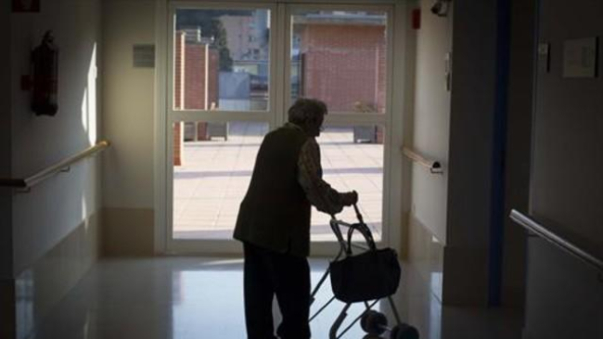 Una anciana pasea en una residencia.