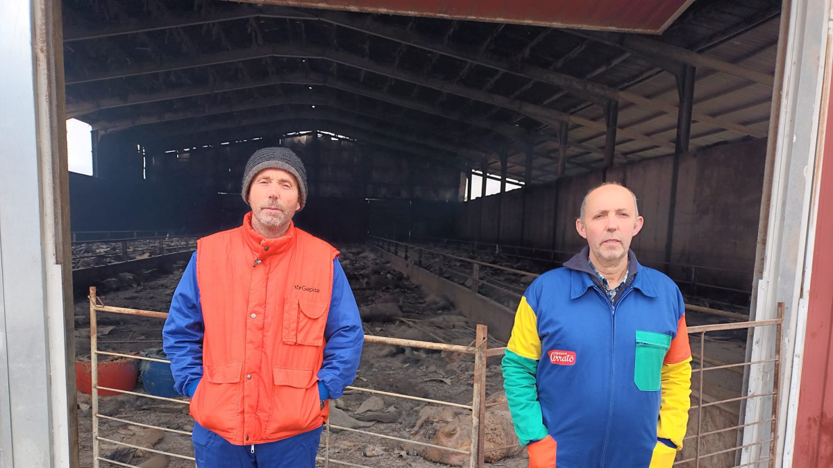 Millán y Benito posan junto a la nave calcinada en Caleruega