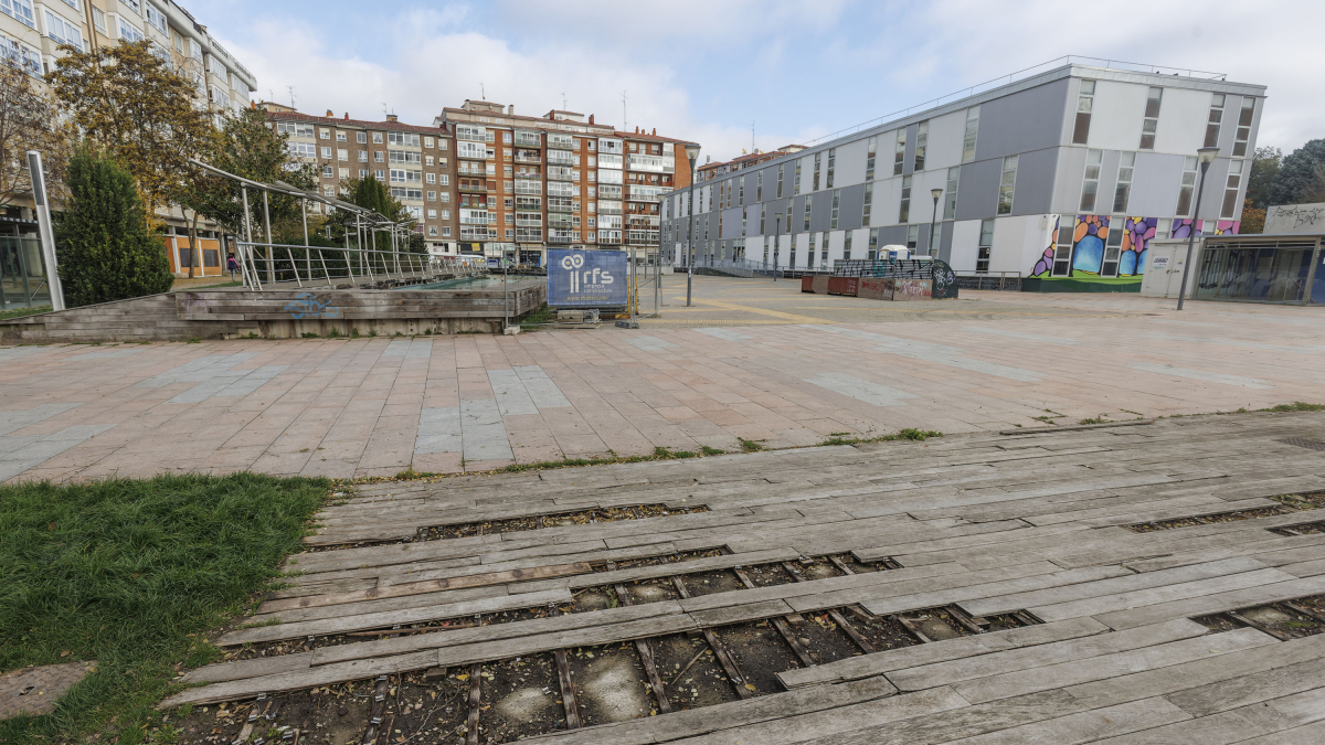 Pavimento del parque Félix Rodríguez de la Fuente deteriorado y vallas de obra, al fondo.