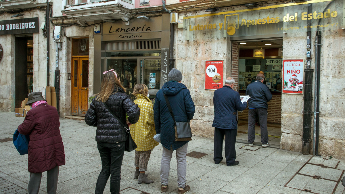 Varias personas hacen cola en la administración de Lotería El Gato Negro de la capital burgalesa.