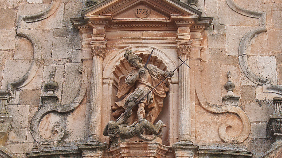 Escultura del arcángel san Miguel en la portada de la iglesia de Mahamud.