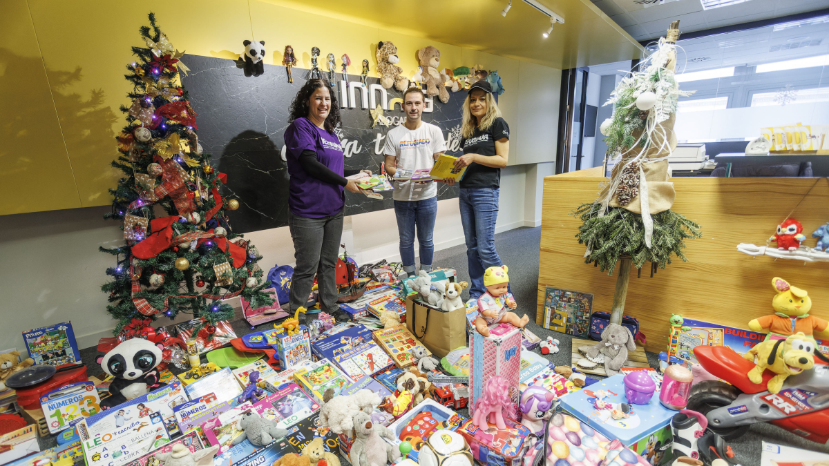 Beatriz Rodríguez, de Innova Abogados, a la derecha de la fotografía, entrega los juguetes a los responsables de Accem.