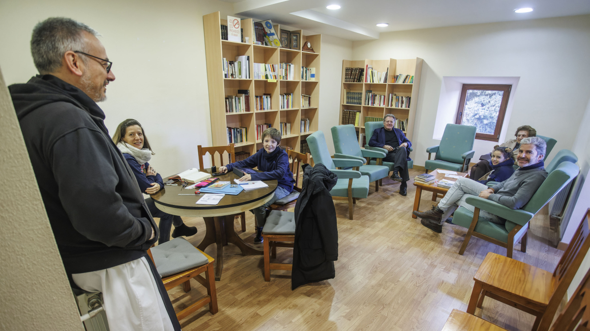 Eduardo, Gloria, Amadeo y Chus -junto a sus hijos, Carla y Lucas- charlan en la pequeña biblioteca de la hospedería de San Pedro de Cardeña con fray José Luis, responsable de la acogida.