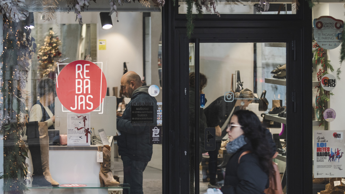 Varias personas miran calzado en una tienda local de la capital burgalesa.