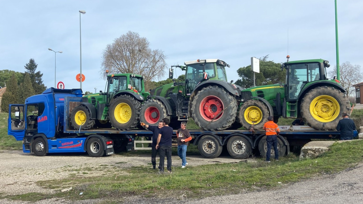 Tres tractores remolcados en una góndola antes de partir desde Burgos en dirección a Madrid.