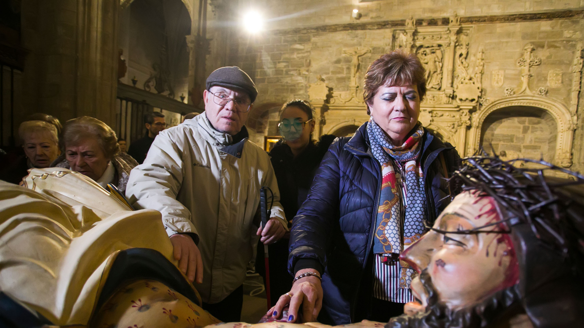 Usuarios de la ONCE palpan el Santísimo Cristo de Burgos en la iglesia de San Gil.