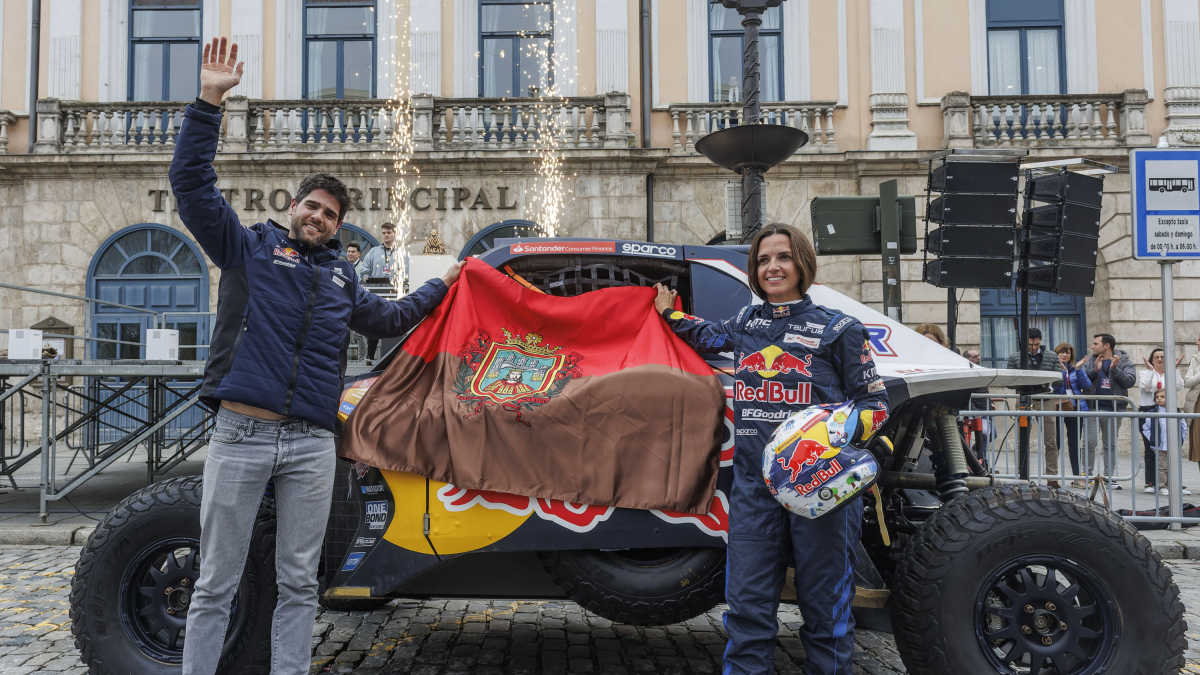 La pareja ganadora del Dakar posa con el coche y la bandera de Burgos