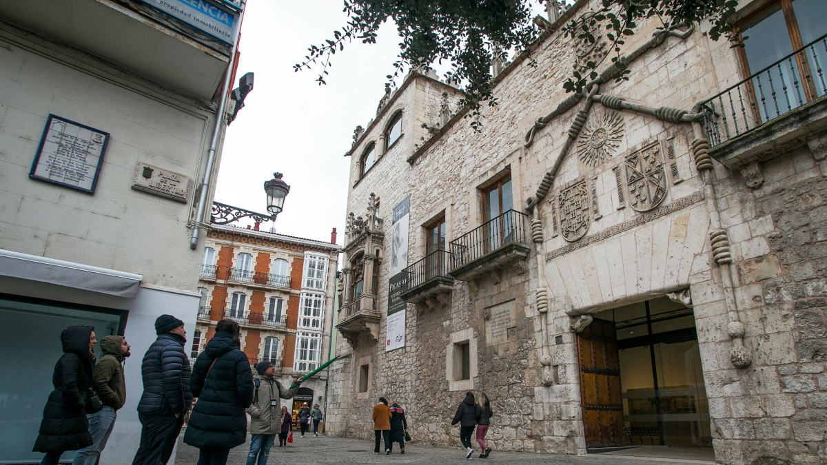 Un grupo de turistas atiende las explicaciones del guía sobre la Casa del Cordón en el mes de febrero
