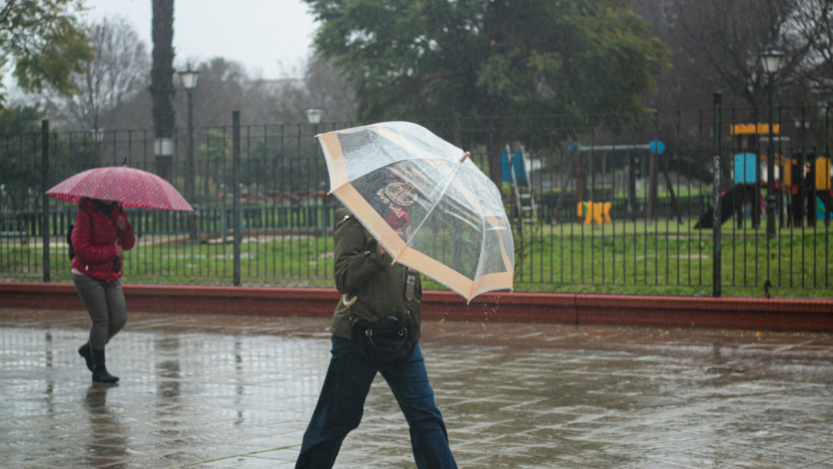 Archivo - Dos personas se protegen de la lluvia bajo su paraguas. A 9 de febrero de 2024, en Sevilla (Andalucía, España). La borrasca 'Karlotta' activa avisos por lluvia, viento y oleaje en todas las provincias andaluzas.
