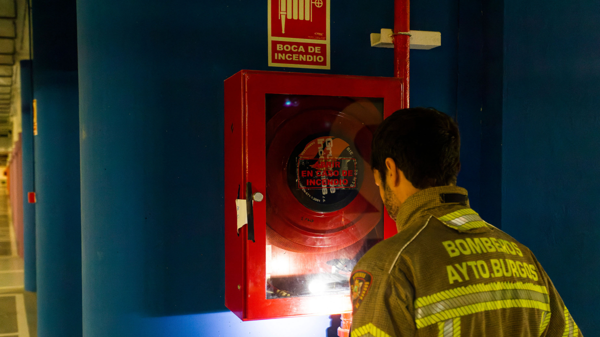 Un bombero observa una boca de incendio.