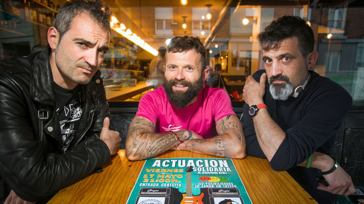 Sergio de la Fuente (centro), flanqueado por Raúl y Pedro, componentes de Triaje, con el cartel del concierto solidario que se celebra este viernes en La Guarida.