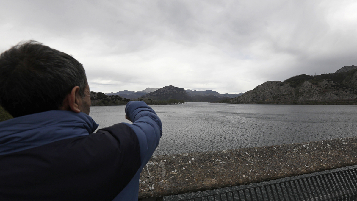 Archivo - Un hombre señala el embalse del río Porma.