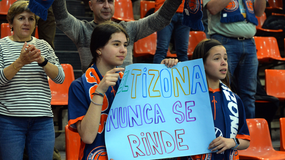Dos jóvenes sostienen un cartel durante el segundo partido con un lema grabado a fuego en la afición.